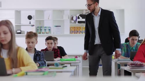 Teacher Helping Students Working in Classroom