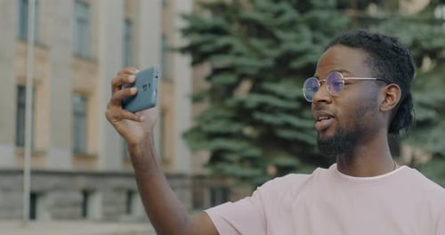 Young Man Records Video in Urban Setting