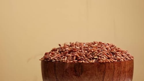 Dry Red Rice in Wooden Bowl Long Brown Rice Rotating Close Up Grains Fall Poured a Stack World