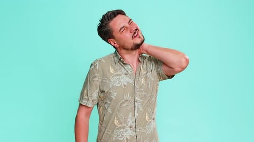 Adult Man Stretching Back and Massaging Neck Showing Signs of Fatigue Muscle Tension After Long Work