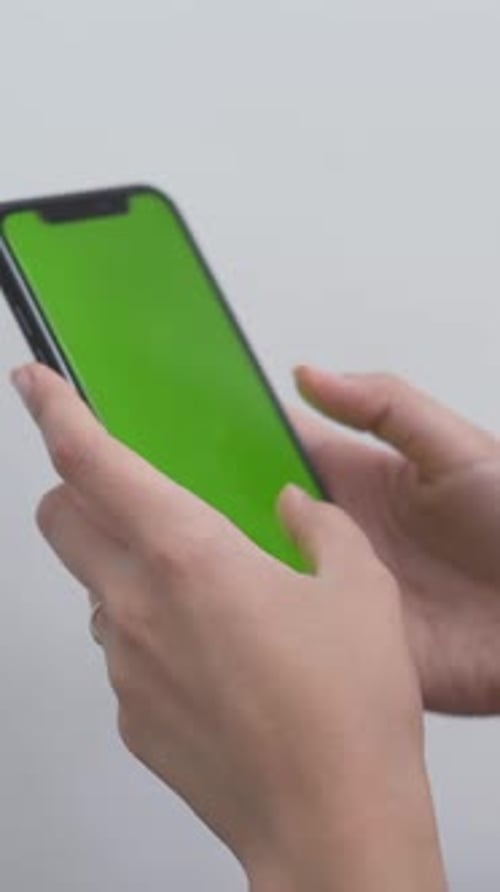 Woman Typing On The Mobile Phone With A Green Screen Close Up