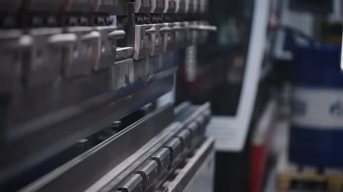 Der Prozess des Biegens von Stahlblechen in der Produktion Ein Arbeiter stellt Teile mit einer Werkzeugmaschine her und einem