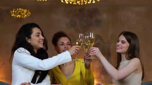 Young Female Friends Toasting and Drinking Champagne While Sitting in the Restaurant and Resting