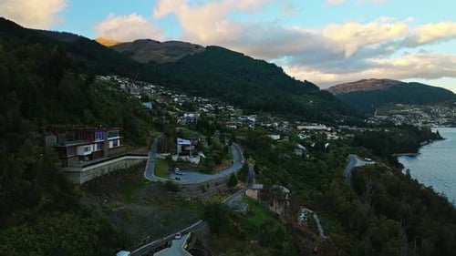 Aerial orbit estabilshing Queenstown New Zealand hidden in shade of mountain