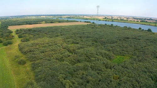 Aerial top view of drone flying above farmland river in the background
