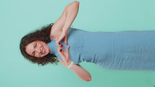 Woman Making Heart Shape Gesture on Blue Background