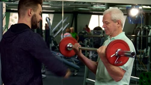 Senior Man Doing Bicep Curls at the Gym