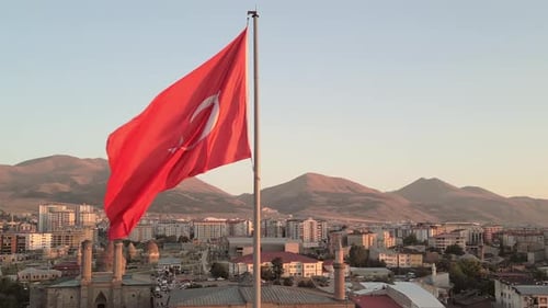 Turkish Flag Waving over Cityscape at Golden Hour