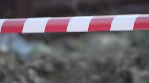 Fita de advertência vermelha e branca balançando no sinal de proteção contra o vento Não cruze a linha vermelha e branca