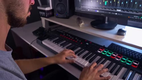 Young Adult Plays Music Keyboard in Studio