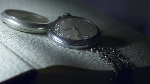 Antique pocket watch with silver chain shows time .Slow Pan close-up