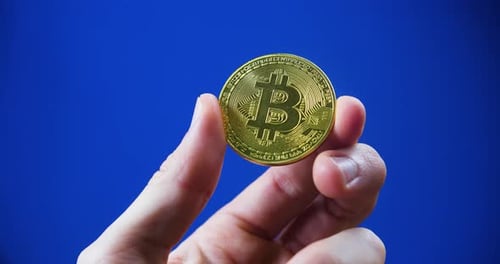 Hand Holding Gold Bitcoin Close Up