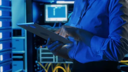 Hands of Female Data Center Engineer Using Tablet in Server Room