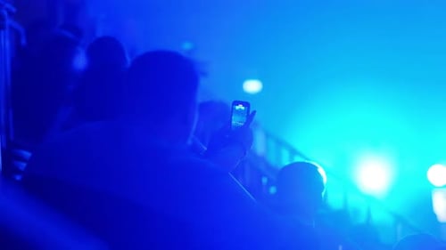 Spectators Shoot a Large Sports Arena on Their Phone Blue Dynamic Light at a Mass Event