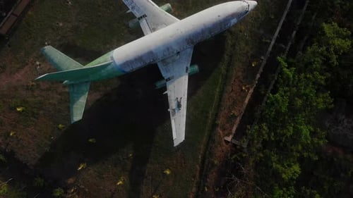Aerial view of abandoned airplane in rustic field, Indonesia.