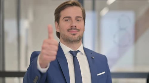Man in Suit Gives Thumbs Up in Office
