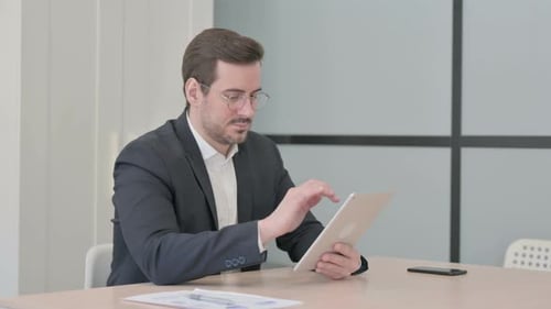 Man in Suit Using Tablet in Office
