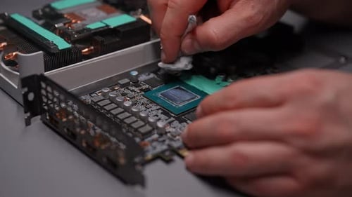 Hands Clean Computer Circuit Board with Cotton Swab