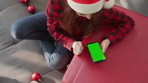 Woman Using Smartphone with Green Screen at Christmas