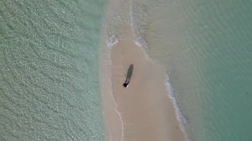 Young Woman in White Dress Walking Alone on Sandy Beach in Maldives Aeral Drone View