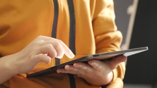 Close up on the hand of caucasian woman pointing and touching the screen of tablet.