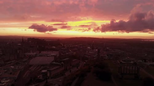 Aerial view of beautiful Edinburgh Scotland during dramatic sunset lowering drone