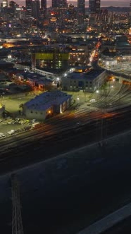 Railway Depot on Riverbank in City at Dusk Tilt Up Revealing Skyline with Downtown Skyscrapers