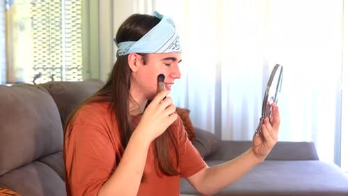 Young Adult Applying Makeup with Brush and Mirror