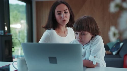 Woman and Child Looking at Laptop Inside Modern Home