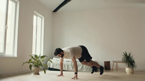 Young Man Practicing Burpee Exercise at Home