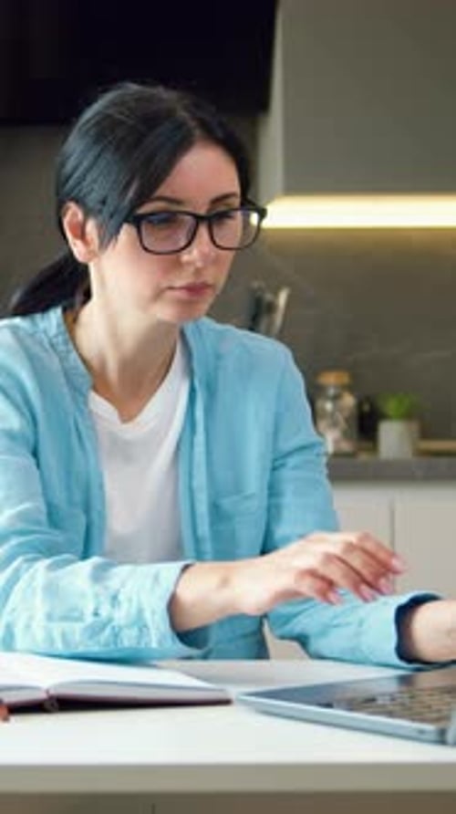 Pretty Business Woman in Eyeglasses Using Laptop on Kitchen Freelancer at Home Office Concept