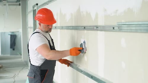 Construction Worker Plastering Wall in Building Interior