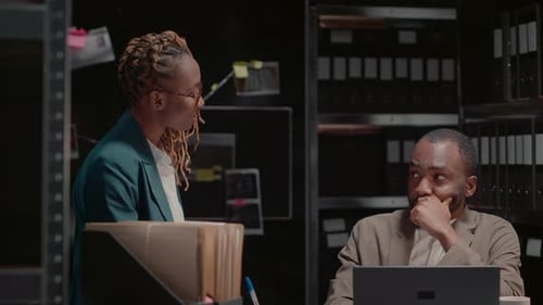 Man and Woman Discuss Case in Dark Office