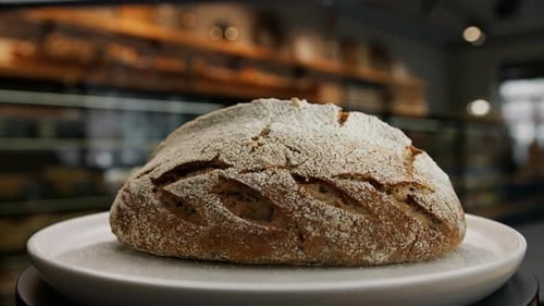 Close-up, bakery - freshly baked dark bread on a rotating surface