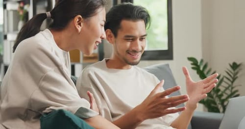Young Couple Using Laptop Together on Couch