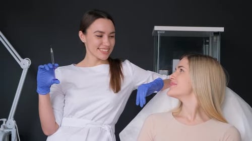 Beautician Holds Syringe near Woman in Clinic