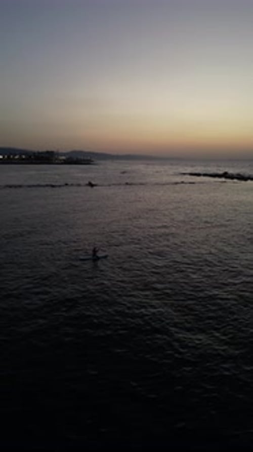Aerial video on Barcelona's coastline people doing a sap.