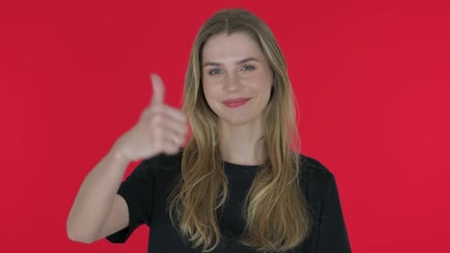 Happy Woman Gives Thumbs Up on Red Background