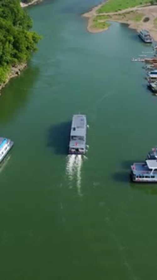 Vertical drone shot following a Lijiang river cruise boat in Yangshou, China