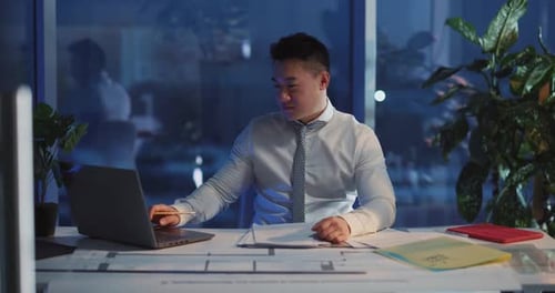 A Focused Professional Engaged in Work Late at Night in a Corporate Office Environment
