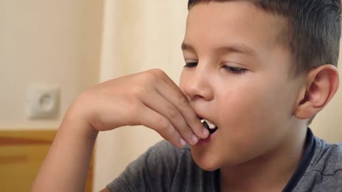 Boy Eating Popcorn Snack Close-Up Indoors