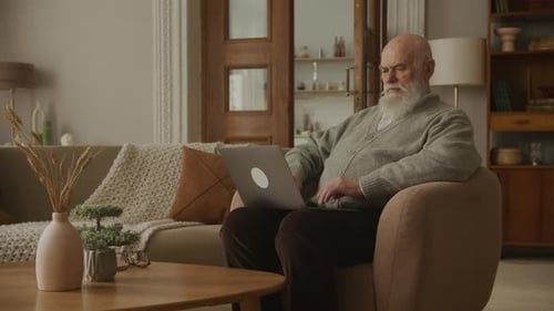 Senior Man Using Laptop Computer at Home
