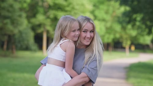 Loving Mother Holding Daughter in Park
