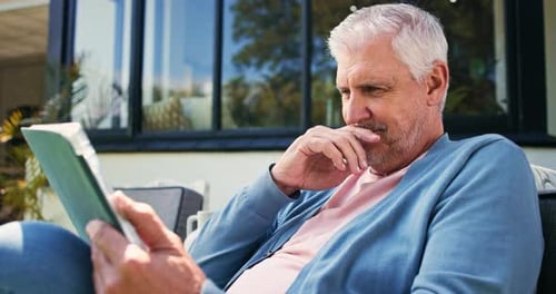 Gray Haired Man Relaxing and Reading Book Outside