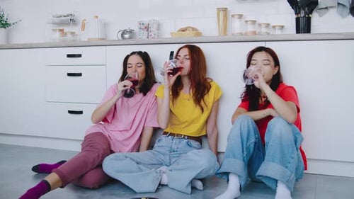 Three Friends Drinking Wine in Modern Kitchen