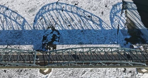 Bridge with traffic over a frozen river with ice floes.
