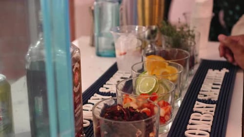 Un camarero profesional vierte refrescos y bebidas heladas en vasos de plástico para preparar un cóctel de alcohol de frutas