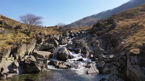Scenic View Of A Rushing Mountain Stream Flowing Over Rocks