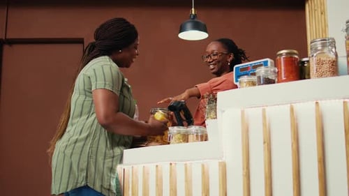 Women Interact at a Counter in a Shop