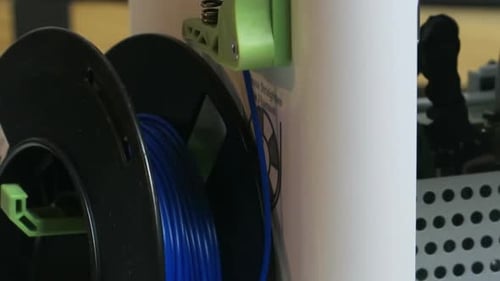 3d printer filament and printer printing a 3d model.